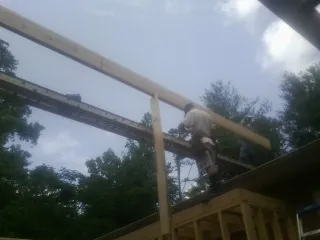 Carpenter setting a ridge beam over a new addition frame — Ice Dam Removal by Roofing Brothers in Goose Creek