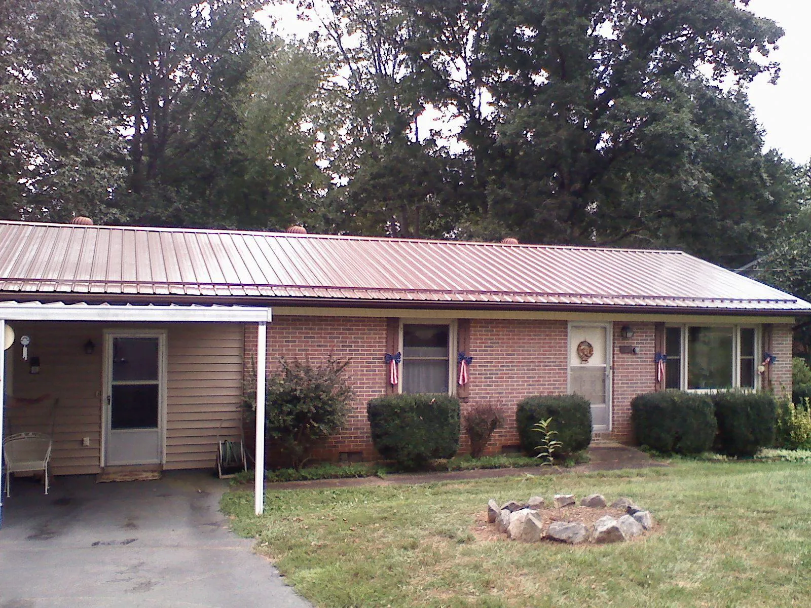 Bronze metal roof and carport on a brick ranch home — Roof Repair work by our crew in Goose Creek