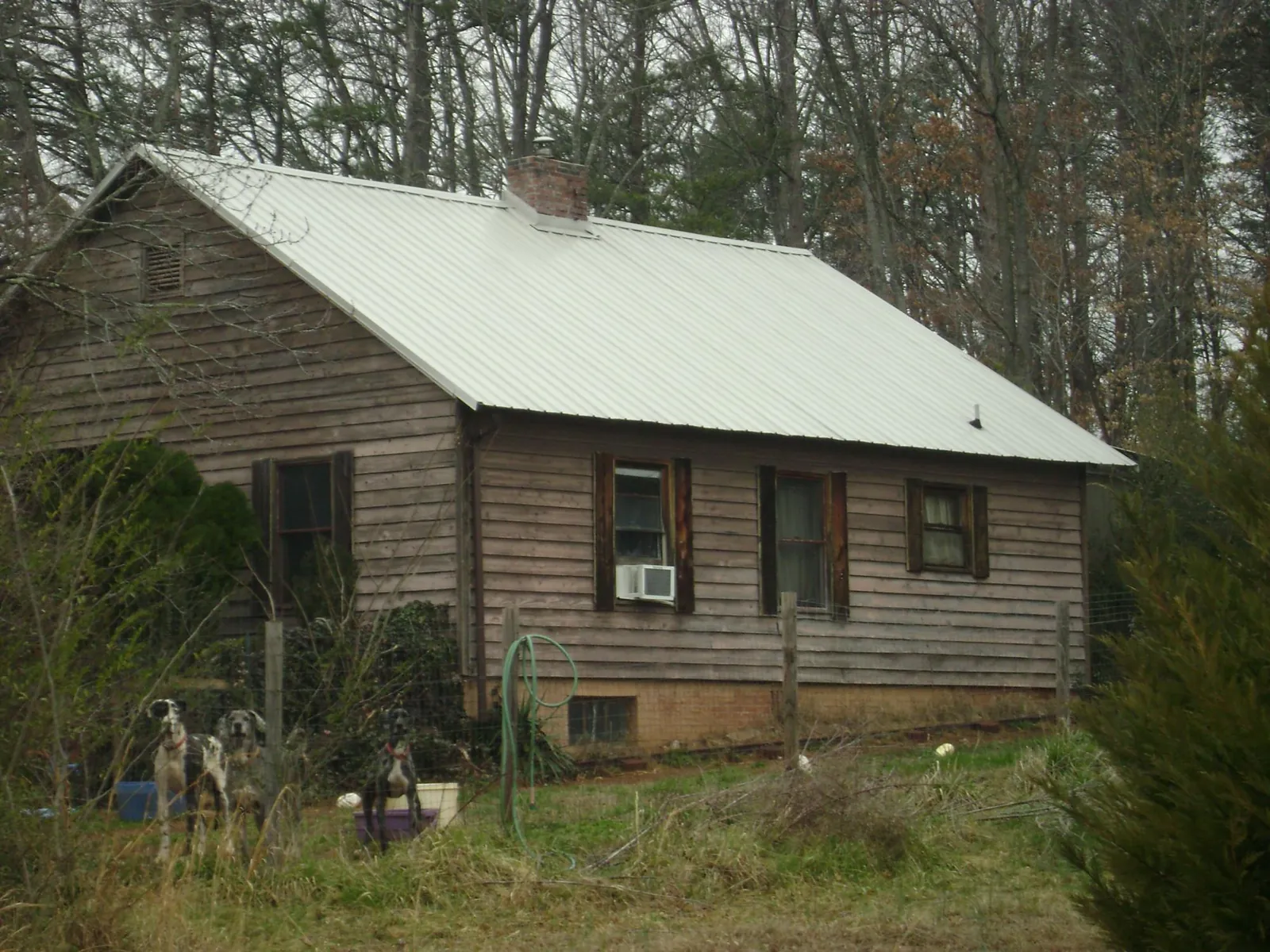 White metal roof on an old wood sided farmhouse, from a Asphalt Shingle Roof Repair job in Goose Creek